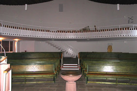 Blick vom Altar aus auf die Kirchenbänke und Empore